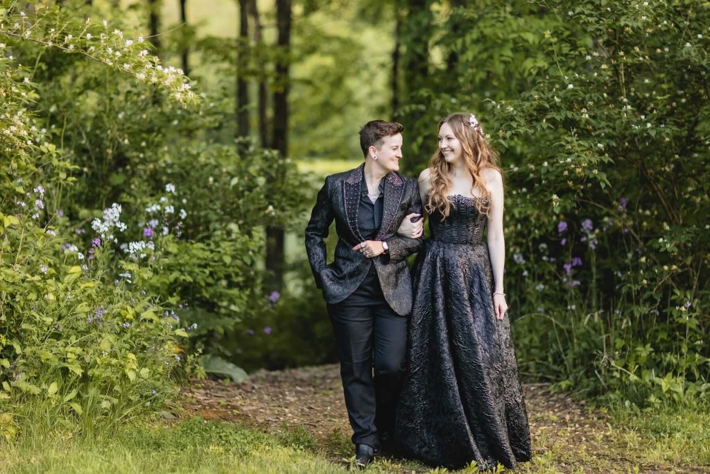 Two brides walking arm in arm on a garden path at an Indiana LGBTQ+ wedding